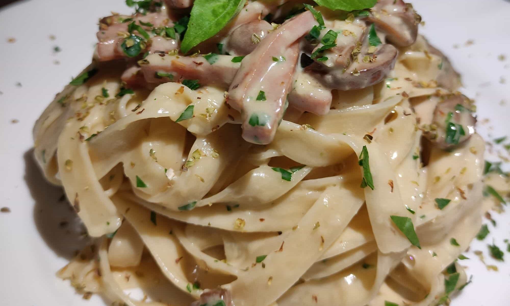 Tagliatelle Prosciutto e Champignon-Tagliatelle mit Schinken und Champignon